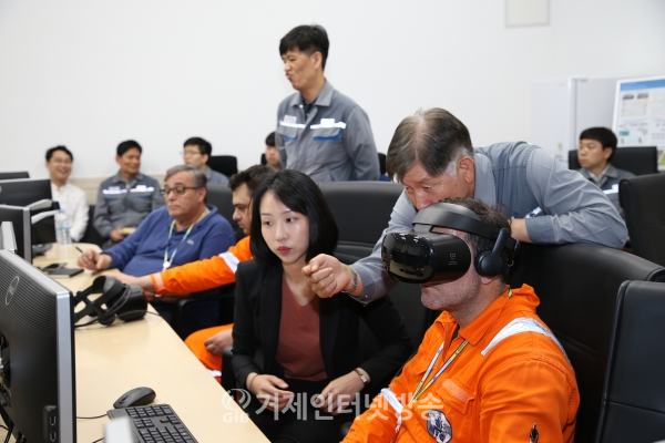 대우조선해양 관계자가 LNG운반선 선원에게 VR 선원교육시스템을 설명하고 있다.